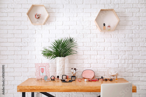 Set of decorative cosmetics and beauty accessories on dressing table indoors photo