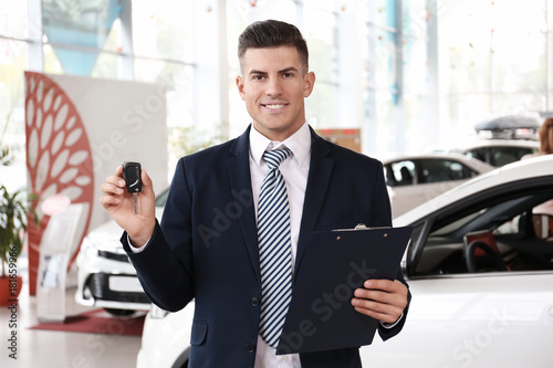 Salesman with key in car salon