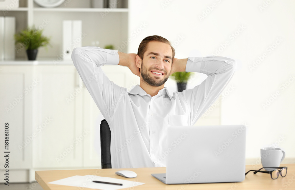 Naklejka premium Attractive man with laptop in office