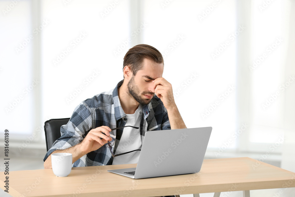 Tired man with laptop in office Tired man with laptop in office