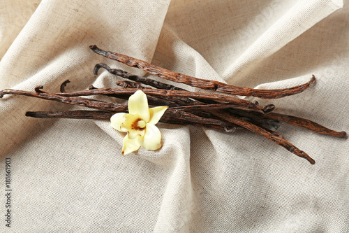 Foto Dried vanilla sticks and flower on cloth