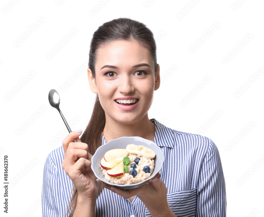Young woman eating oatmeal on white background Young woman eating oatmeal on white background