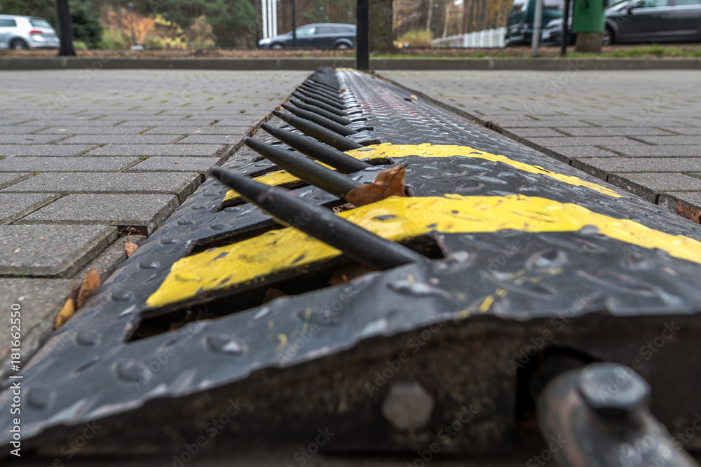 Tire puncture spike strip - stoping line with big spike to stop car. Tire  spikes being used at the exit to a park or hotel or security areas  Stock-Foto | Adobe Stock