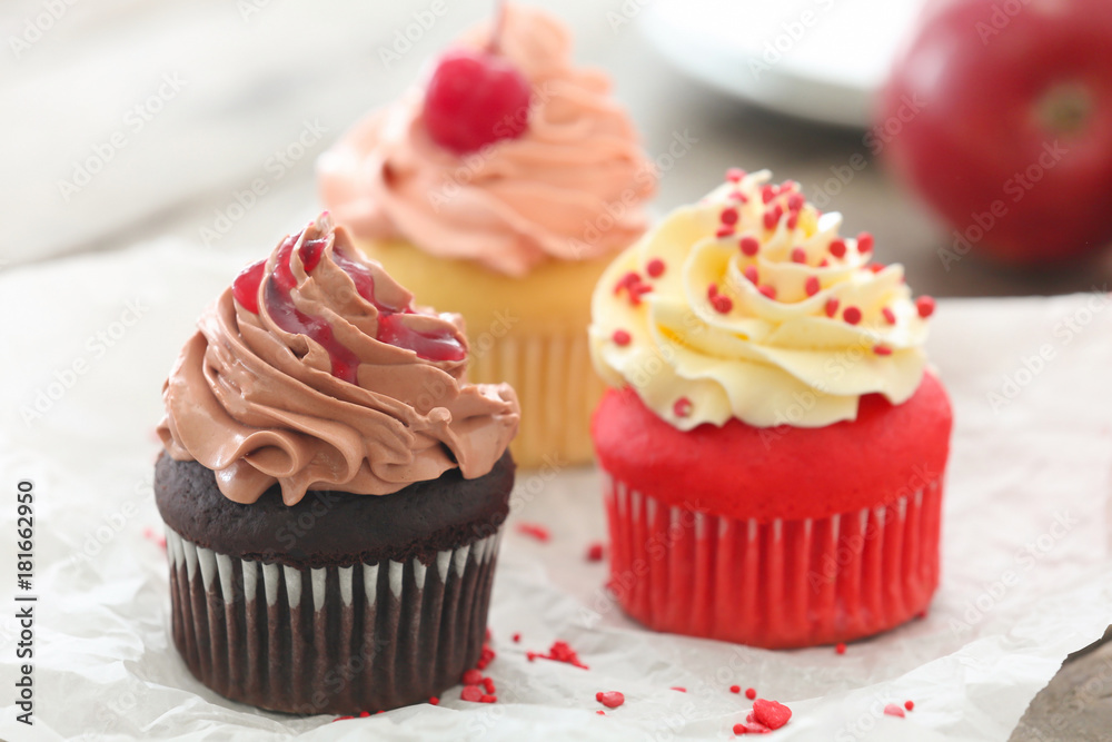 Delicious cupcakes on table