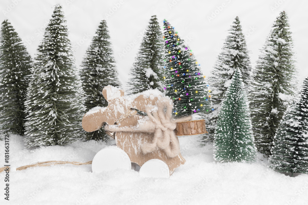 forest winter wonderland with figurines in snow setting deer figurine  carrying home a pinetree christmas tree in the foreground Stock Photo |  Adobe Stock