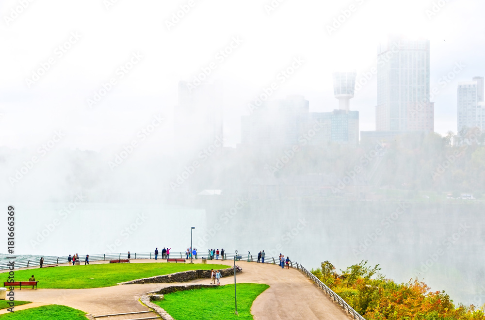 View of Niagara Falls from American side with water sprayed in the air.