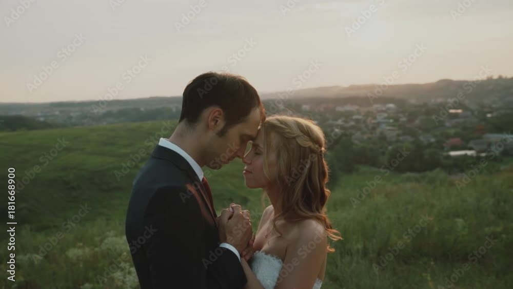 Lovers in a field at sunset.Girl and guy holding hands .Happy couple smiling. Lovers in a field at sunset.Girl and guy holding hands .Happy couple smiling.