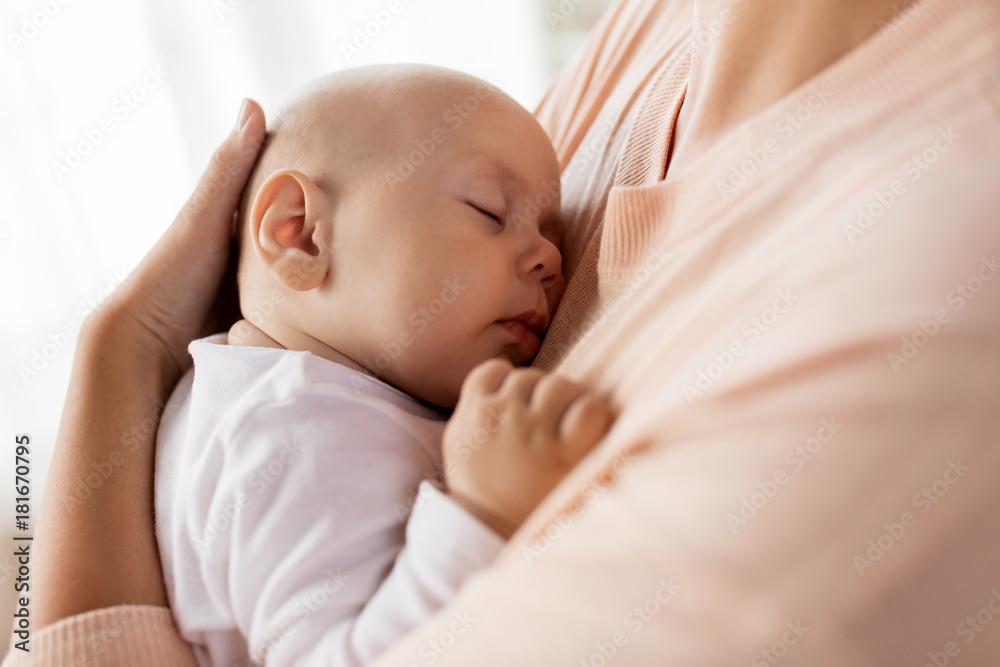 close up of mother holding sleeping baby close up of mother holding sleeping baby