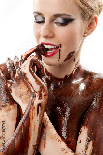 amazing blonde female model covered in chocolate tasting a Belgiane chocolate praline with great makeup and red lips a clear tempation