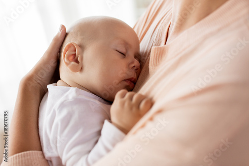 close up of mother holding sleeping baby