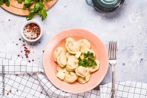 Boiled dumplings in a gray plate on a gray background  parsley  horizontal