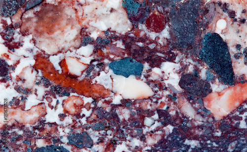 Red marble mineral stone texture pattern macro view. Beautiful ornamental metamorphic rock composed of recrystallized carbonate minerals calcite dolomite. Multicolor gem background photo