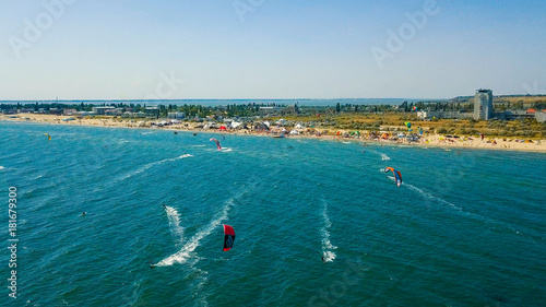 Aerial view of kitesurfing extreme sport with the wind freestyle. Beautiful top view of nice beach. Lots of kites