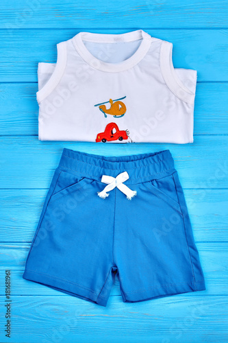 Baby boy cotton summer suit. Newborn baby boy clothes set on blue wooden background. © DenisProduction.com