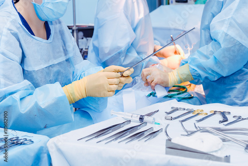Close up hands of surgery assistant holding steralized surgical tools for laparoscopic surgery. Selective focus photo