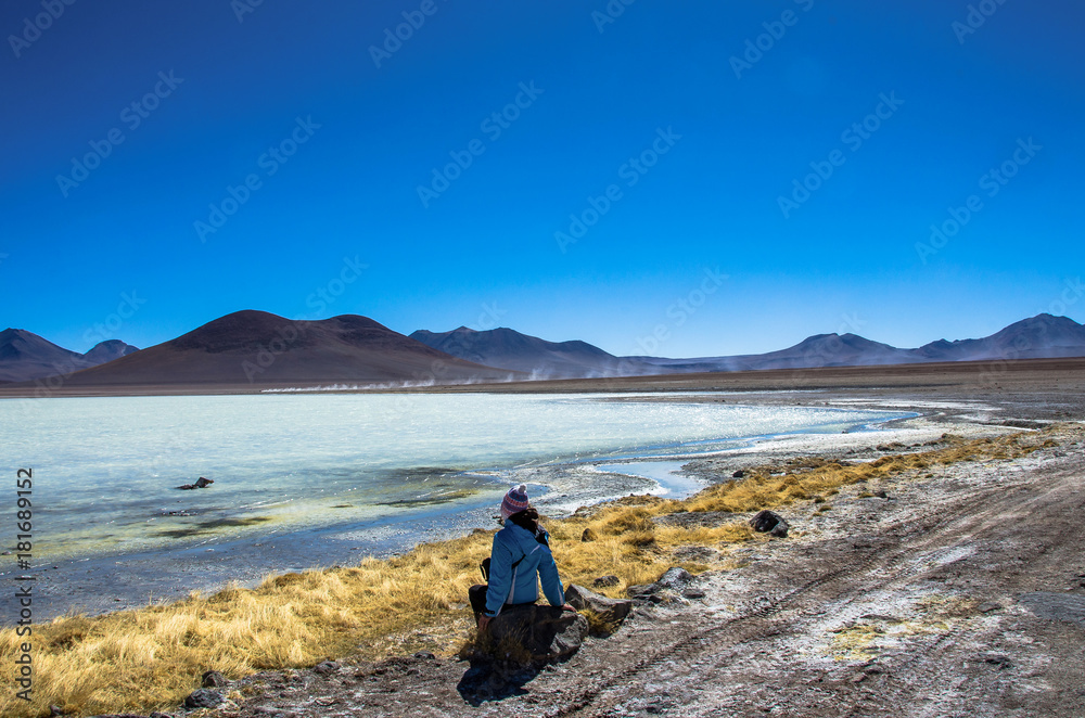Girl seatting on the Laguna Verde is a salt lake at the foot of the volcanos Licancabur and Juriques - Eduardo Avaroa Andean Fauna National Reserve, Bolivia