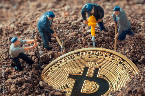 macro miner figurines digging ground to uncover big shiny bitcoin photo