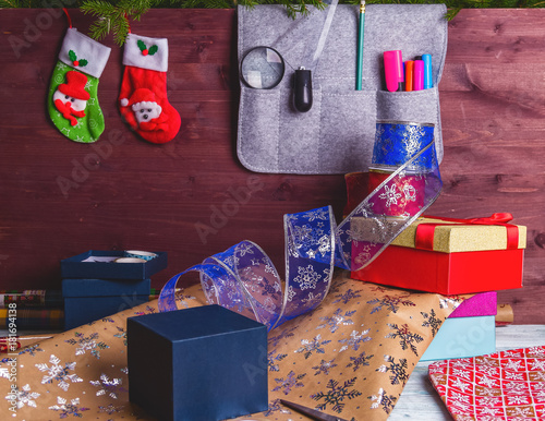 Package christmas gift box. New year christmas wrapping paper, ribbon, bow and thread, scissors, christmas tree on wooden background. Winter time new year photo