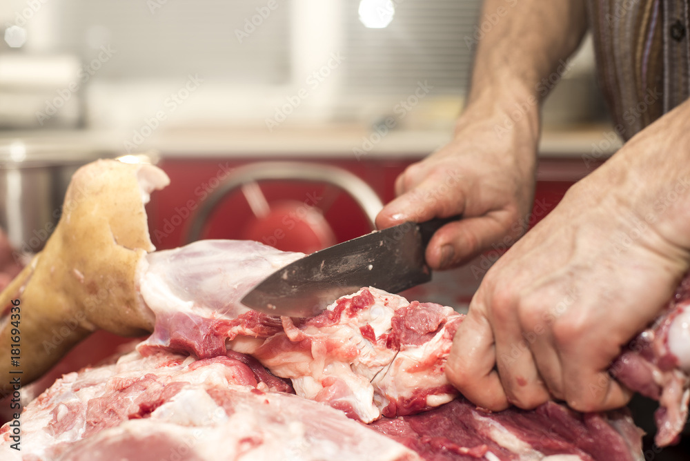Man slicing pork meat on a table, conceptual idea