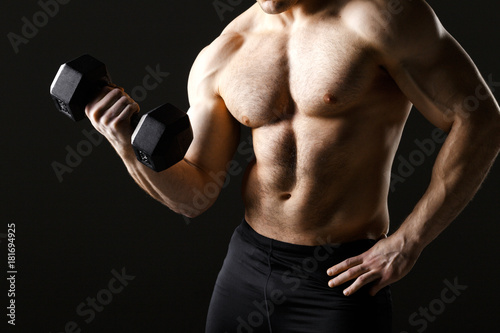 Powerful muscular man holding metal workout weight