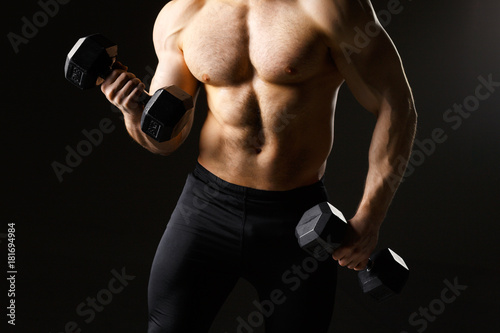Powerful muscular man holding metal workout weight