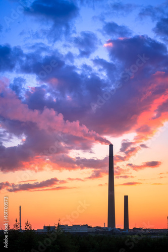 View of a smelter stack of a nickel plant showing the emission on the air with sunset sky as as background