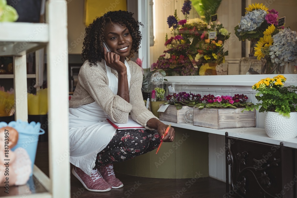 Female florist talking on mobile phone