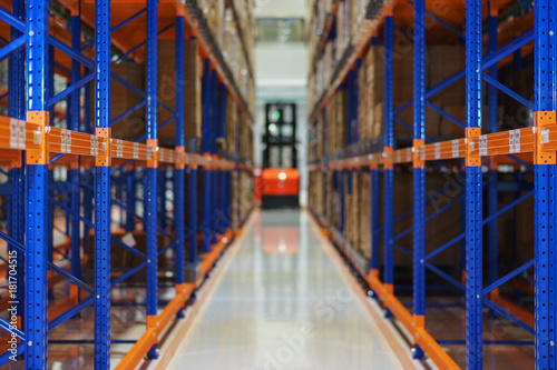 Electric forklift between large shelving in a modern storage building.