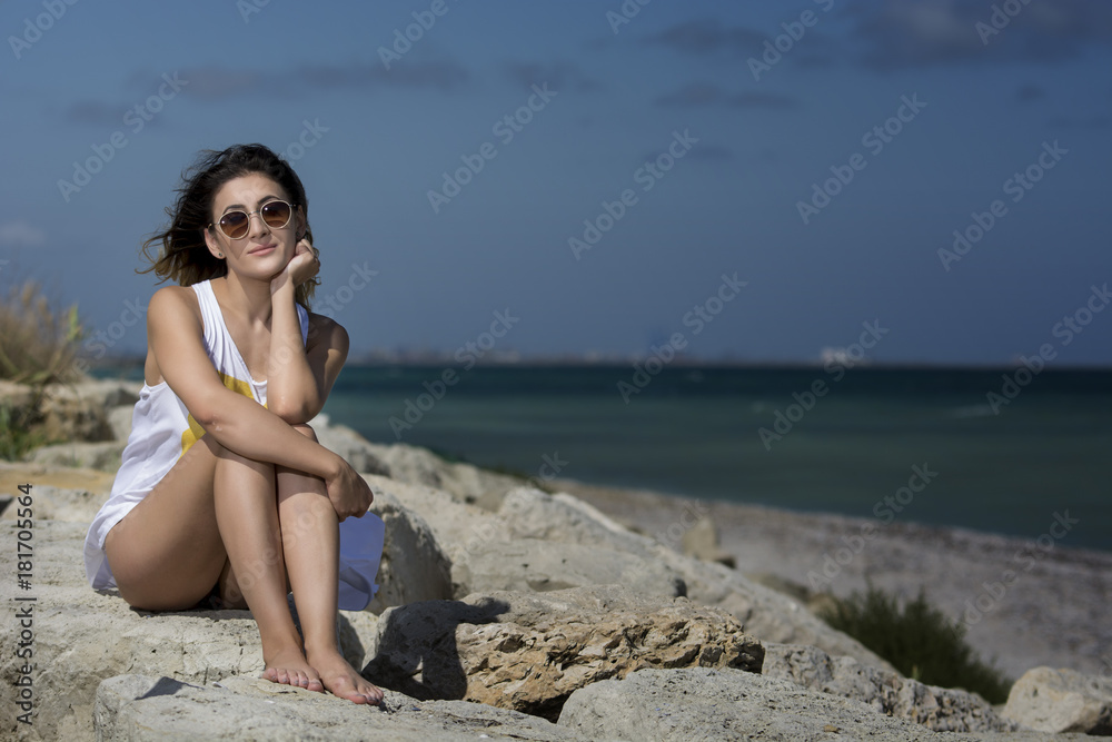 Beautiful young woman enjoying nature by the sea