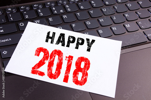 Writing Happy 2018 text made in the office close-up on laptop computer keyboard. Business concept for Holiday Celebration Workshop on the black background with copy space photo