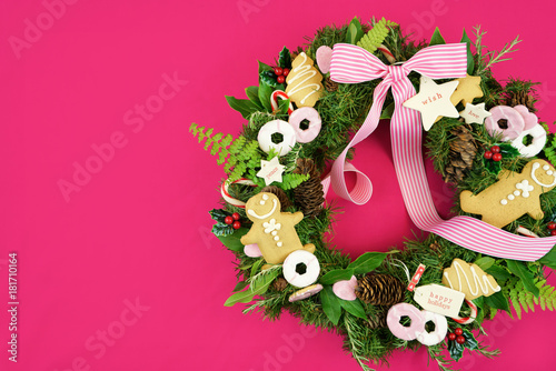 Christmas holiday wreath using fresh herbs  leaves  gingerbread  cookies  candy and gift tags  with copy space.