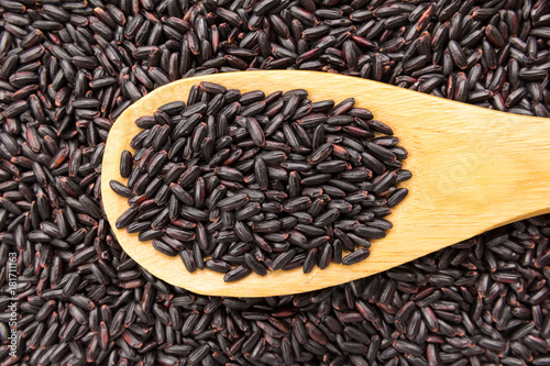 Black Rice seed. Grains in wooden spoon. Close up.