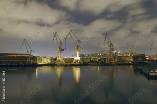 Monumental Cranes at sunrise in Shipyard. Night activity at the naval factories surrounding the city of Bilbao  Spain.