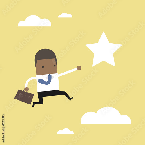 African businessman jumps to reach out for the star.