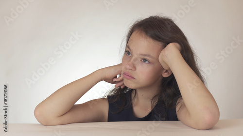 Beautiful sad teenage girl expresses resentment and sadness on white background