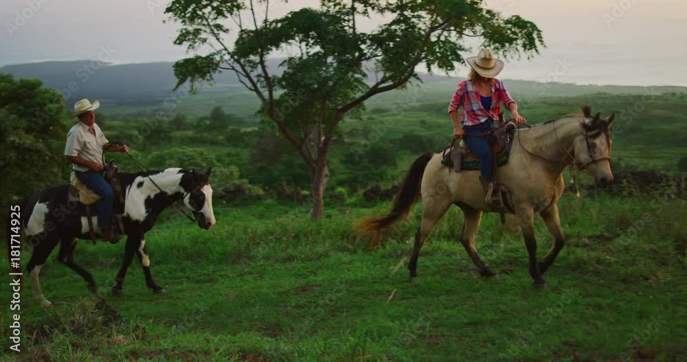 Couple horseback riding together at sunset Couple horseback riding together at sunset