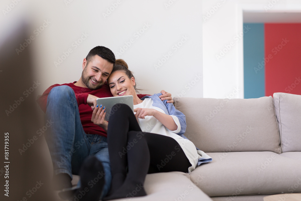 couple relaxing at home with tablet computers couple relaxing at home with tablet computers