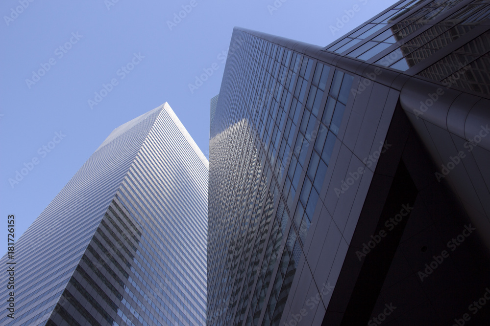 Abstract Blue Glass Skyscraper Buildings in City looking up at Sky with Reflections