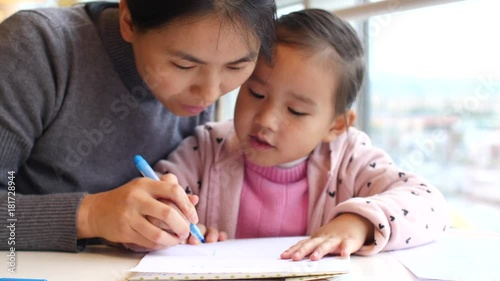 little girl doing homework study indoor by the window