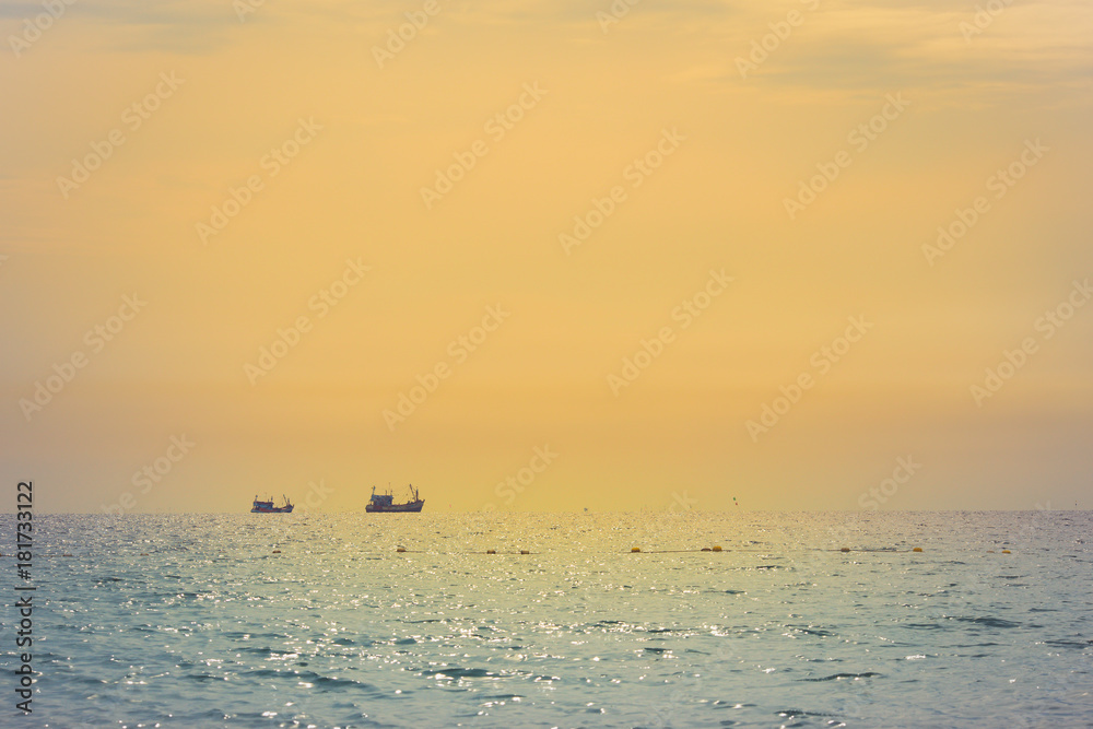 Sea and sky with fishing boat at sunset.