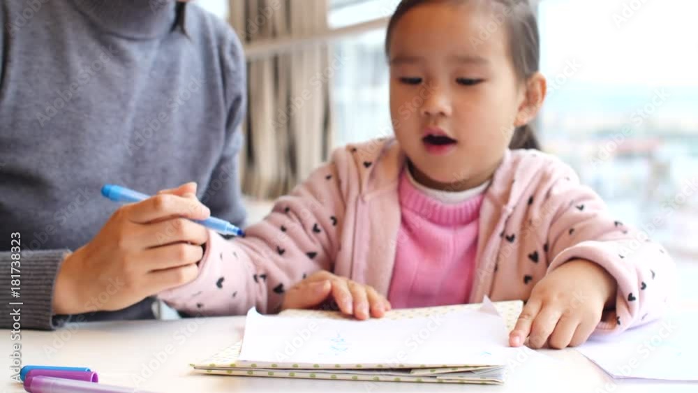 little asian girl doing homework together with her mother little asian girl doing homework together with her mother