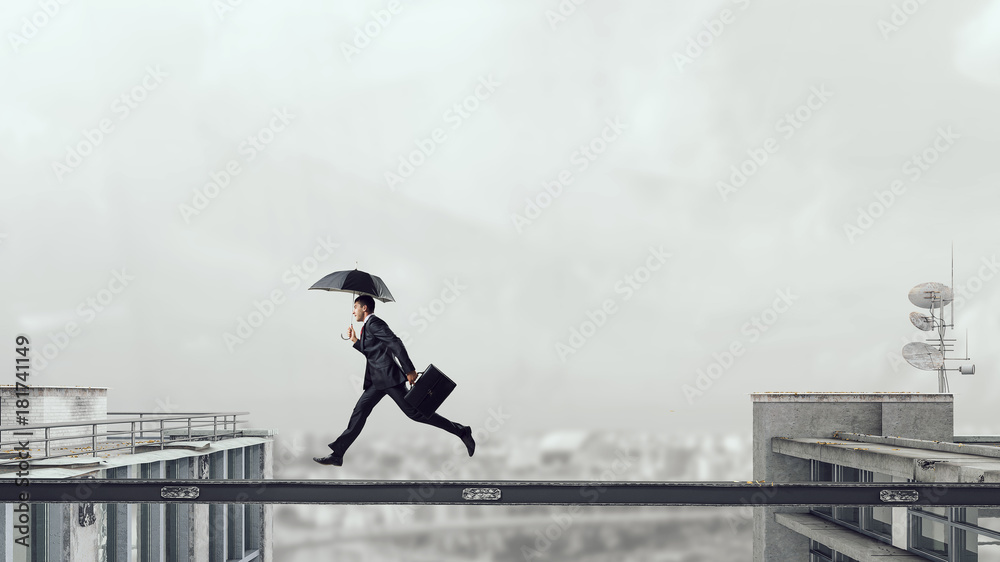 Fearless businessman overcoming difficulty. Mixed media Fearless businessman overcoming difficulty. Mixed media