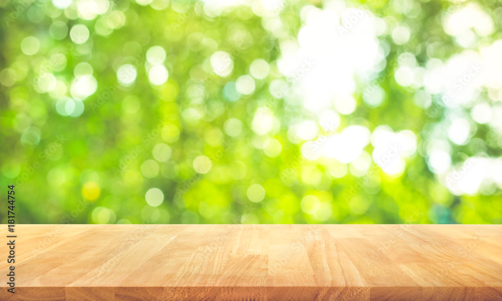 Wood table top on blur abstract green from garden in the morning background.For montage product display or key visual layout Wood table top on blur abstract green from garden in the morning background.For montage product display or key visual layout