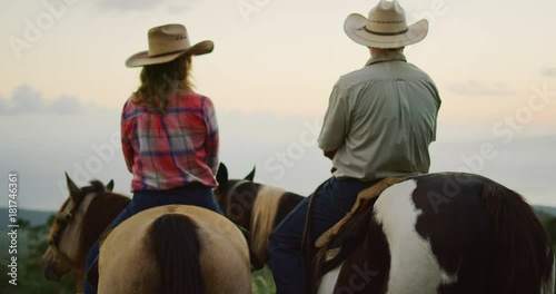 Couple horseback riding together at sunset