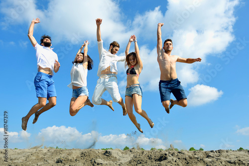 Image of young people jumping together outdoor.