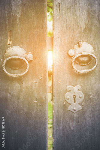 Billede på lærred Two old iron ring handles on a door standing ajar