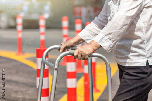 Senior woman using a walker cross street.