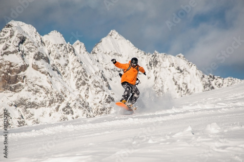 Active snowboarder riding on the mountain slope