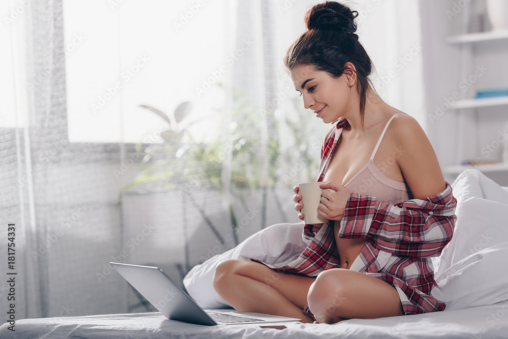girl with laptop drinking coffee in bed girl with laptop drinking coffee in bed