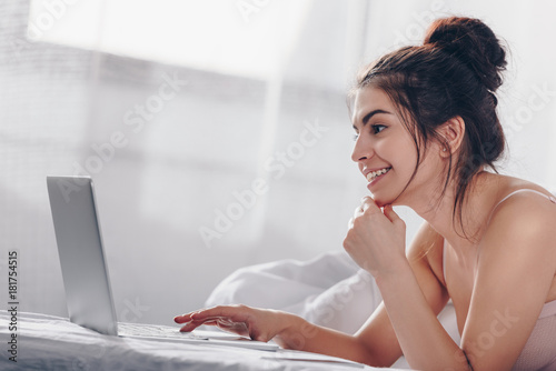 girl using laptop in bed
